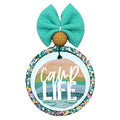 Camp Life graphic with layered mountain, lake and camper landscape