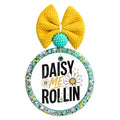 Daisy Me Rollin text with white daisies and gold accents.