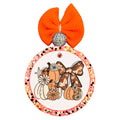 Fall pumpkin arrangement with cow-print bow, daisies, floral accents, and warm neutral colors.