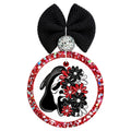Black ghost face mask partially covered with red, black, and white flowers.