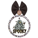 Zebra-striped ghost with star earrings surrounded by black and gold stars above the word Spooky.