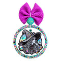 Illustrated witch in a wide-brimmed hat with colorful jewel-style details and crescent moons.