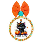 Pumpkin season lettering beneath a black kitten in a witch hat, surrounded by orange pumpkins and autumn leaves.