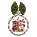 Holiday wine time lettering with a Highland cow, wine glass, red bows, and festive decorations.