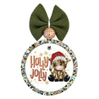 Holly jolly lettering beside a seated Highland cow wearing a red Santa hat, with small gold snowflakes.