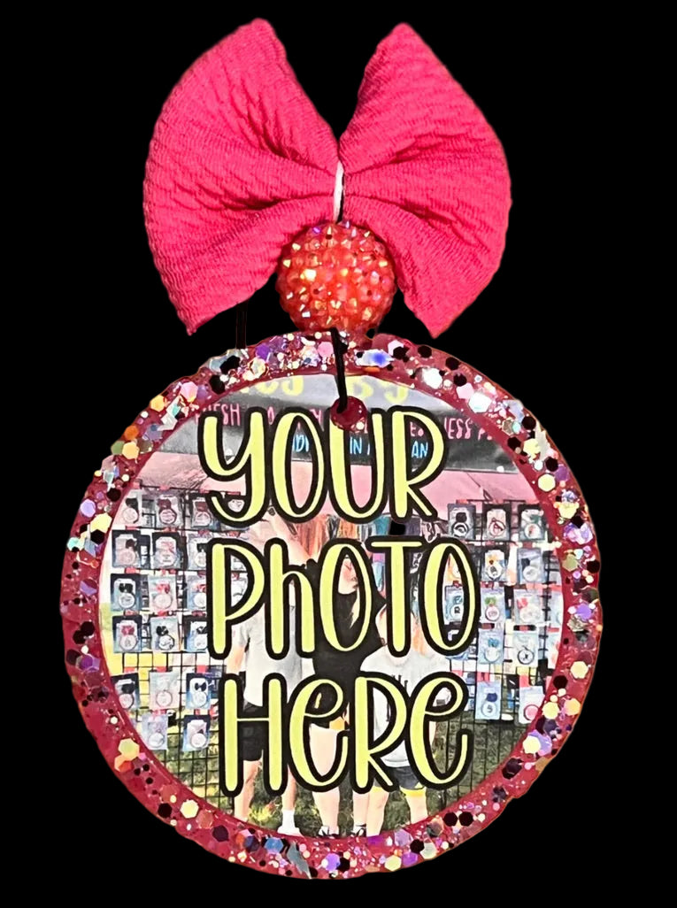 Decorative mirror with a pink bow and text 'Your Photo Here' on a wooden surface