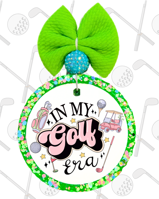 Decorative wreath with a green bow, colorful text, and golf-themed design on a white background.