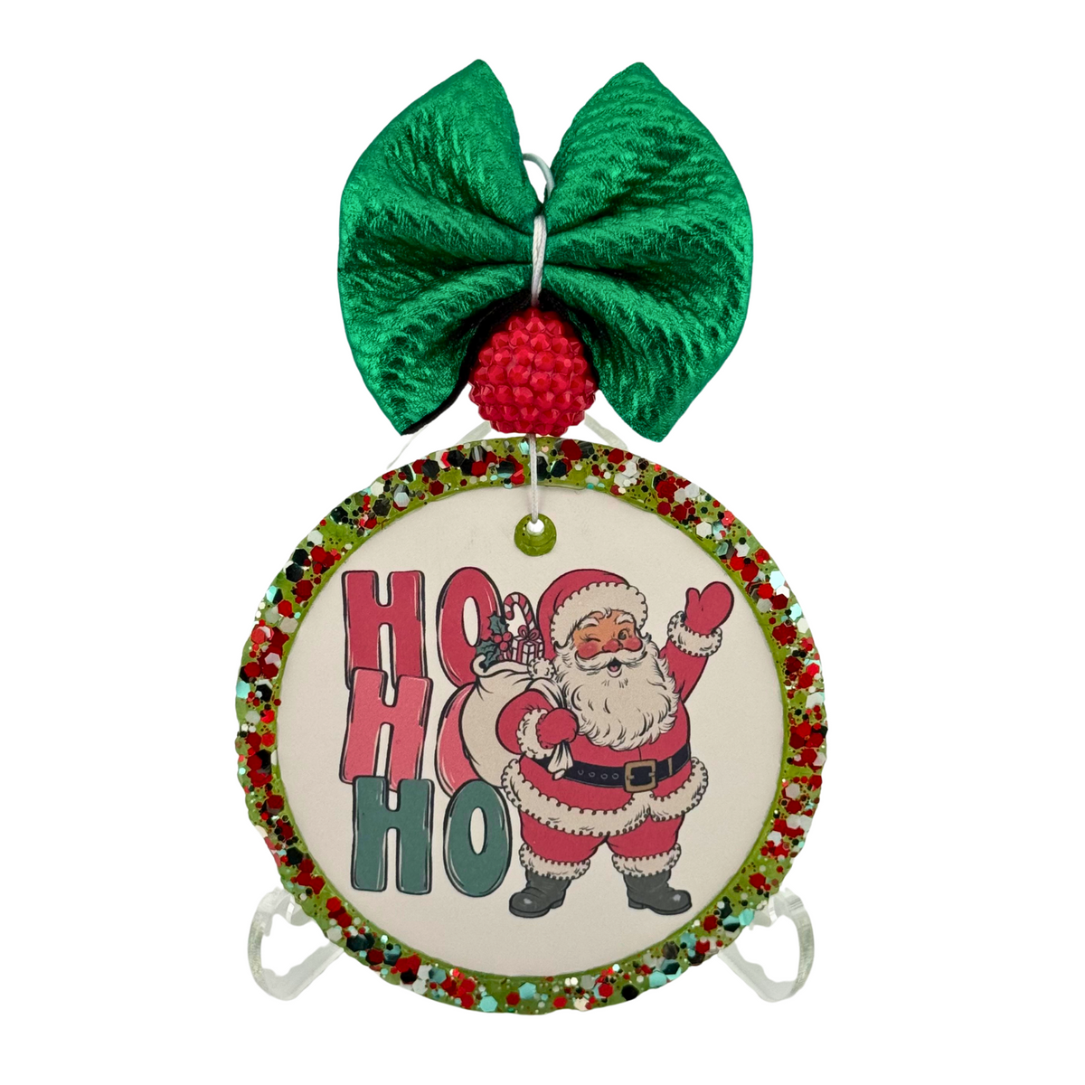 Ho Ho Ho in red and green block letters beside a standing Santa waving.